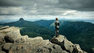 Hiker atop Cradle Mountain, view at Barn Bluff, Cradle Mountain Lake St Clair National Park, Tasmania, Australia