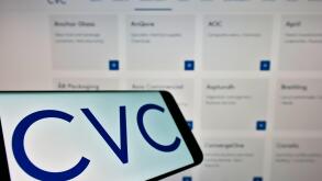 Smartphone with logo of private equity company CVC Capital Partners on screen in front of business website. Focus on center-left of phone display.