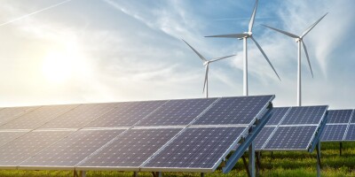 solar panels and wind generators under blue sky on sunset