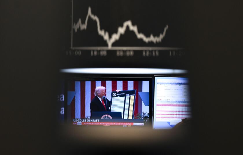 09 April 2025, Hesse, Frankfurt/Main: US President Trump can be seen on a screen on the trading floor of the Frankfurt Stock Exchange in front of the display board showing the Dax curve. There is no solution in sight in the international dispute over tari