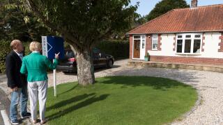 House buyers viewing a house with a for sale sign. England UK