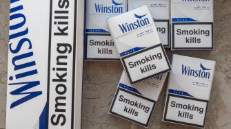 Winston blue cigarettes packaging features prominent health warnings in English, which state "Smoking kills" and "Smoking seriously harms you and othe