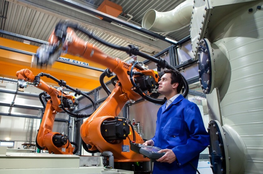 Dortmund, North Rhine-Westphalia, Germany - high technology in the Ruhr area. A technician from carat robotic innovation GmbH programs an articulated