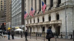People walk past the New York Stock Exchange (NYSE) on Wall Street on March 4, 2026 in New York.