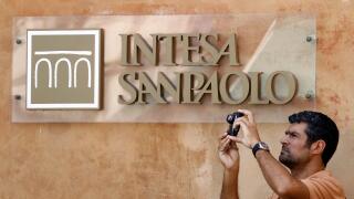 A man takes a picture in front of Intesa Sanpaolo bank in downtown Rome July 23, 2010. The European Union is examining whether some banks need to raise capital as it looks to dispel concerns about weakness in the sector and repair an interbank lending mar