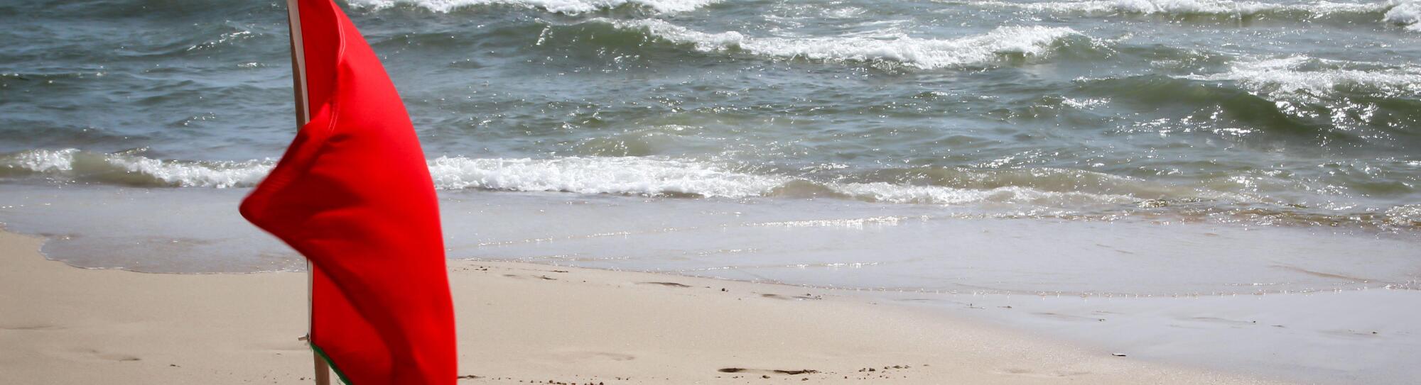 Flags on the beach indicate dangers like jellyfish, undercurrent and other dangers. Image shot 12/2019. Exact date unknown.