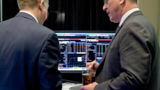 Investors talking in front of computer screen showing stock market trends - USA