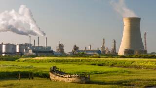 A chemical plant on the bank of the Humber estuary with derelict boat beached in the mud bank.