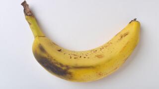 Bruised banana skin on white background shot from directly above