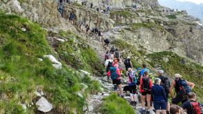 Group of hikers queing to climb up Mount Rysy (2501m), highest summit of Slovakia and peaks of the Tatras, showcasing overtourism in summer