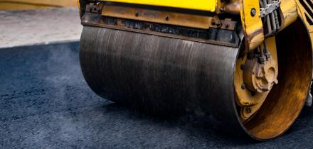 Compact steamroller flatten out the asphalt.