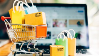 Product package boxes and shopping bag in cart with laptop compu