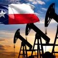 Oil rigs against the backdrop of the colorful sky and a flagpole with the flag State of Texas. The concept of oil production, minerals, development of