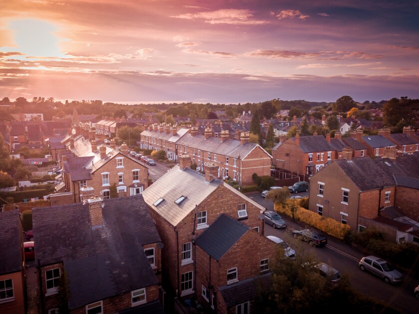 Sun setting with atmospheric effect over traditional British hou