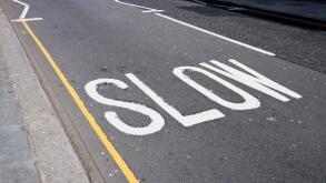 Close-Up of road marking saying Slow in London, UK