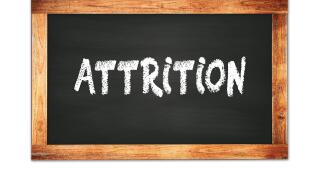 ATTRITION text written on black wooden frame school blackboard.