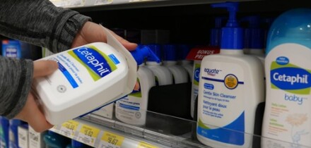Woman taking Cetaphil gentle skin cleanser inside Walmart store