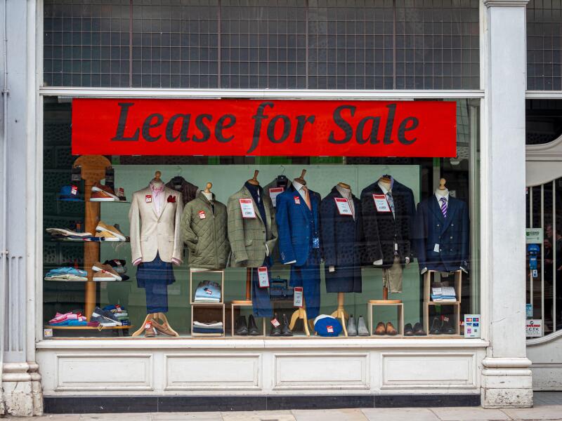 Lease for Sale banner sign in the window of a tailors shop in London.