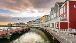 Dutch, modern, colorful vinex architecture style houses at waterside during dramatic and clouded sunset. Houten, Utrecht.
