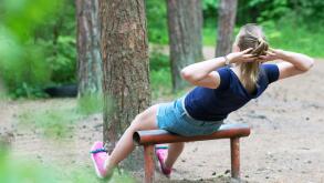 Woman doing abs workout in the forest.