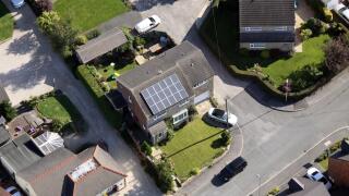 aerial view of a domestic house with solar panels on the roof, UK