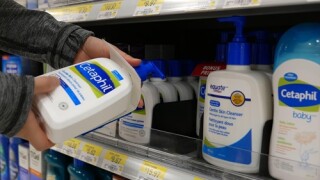 Woman taking Cetaphil gentle skin cleanser inside Walmart store