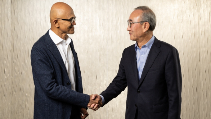 Microsoft CEO Satya Nadella shakes hands with Young-Shub Kim, CEO of KT Corp