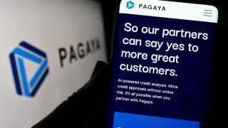 Person holding cellphone with webpage of financial company Pagaya Technologies Ltd. on screen in front of logo. Focus on center of phone display.