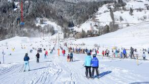 Engelberg, Switzerland - 6 January 2017: people going up with the ski lift and skiing down the slope of Engelberg in the Swiss Alps