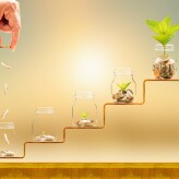 Investor hand hold and drop a gold coin in the five bottle and p