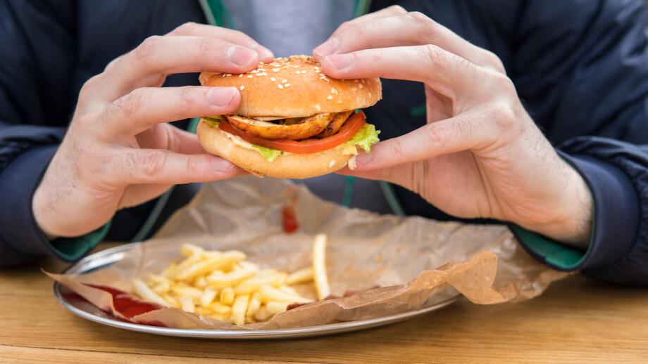 close up view of man's hands with american burger.