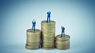 Financial concept. Business people standing on coins piles. Macro photo