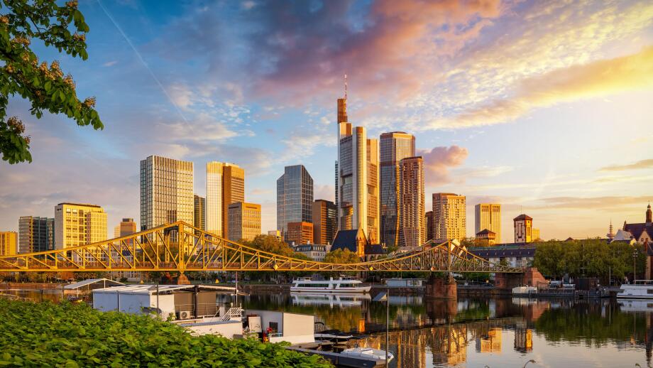 Golden sunrise view of the skyline of Frankfurt am Main, Germany, with banking skyscrapers, Eiserner Steg Bridge and River