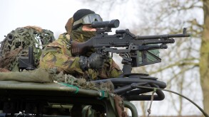 A soldier of the dutch army is aiming his automatic weapon during a training in the winter