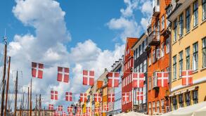 Danish flags and colorful buildings in Nyhavn, Copenhagen in Denmark.