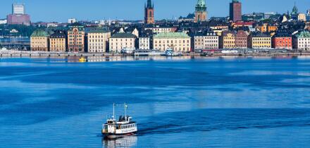 Early morning view of Stockholm waterfront building on Stadsholmen island with Stockholm ferry in foreground, Stockholm, Sweden, Northern Europe