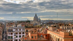 Over the roofs of Rome, view from the church Trinita dei Monti at the center of the bustling metropolis with its domes and roofs