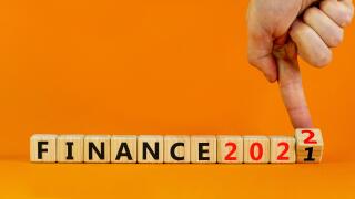 2022 finance and new year symbol. Businessman turns wooden cubes, changes words 'finance 2021' to 'finance 2022'. Beautiful orange background, copy sp