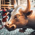 Wall Street charging bull statue in New York City with people