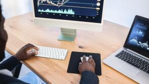 African trader studying stock market at home - Focus on right hand