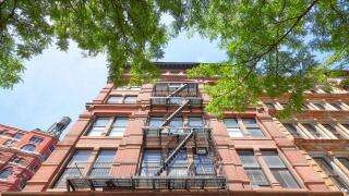 Looking up at an old building with fire escape, New York City, USA.