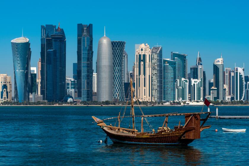 Dhow traditional sailing vessel with the financial area skyline behind, Doha, Qatar