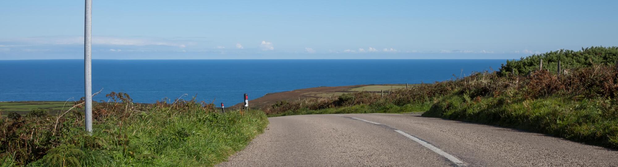 A street to the ocean with a sign and the warning word slow
