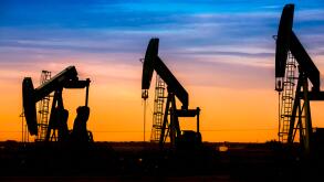 Silhouette of Oil pumps at oil field with nice sunset sky background