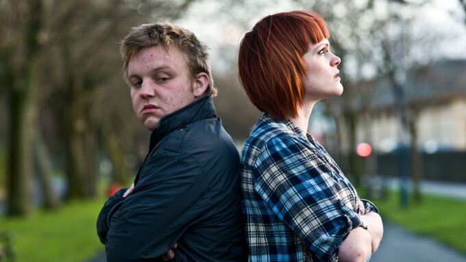 A young couple man and woman having an argument standing back to back not speaking to each other; sulking, not talking