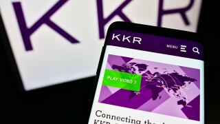 Mobile phone with webpage of US investment company KKR and Co. Inc. on screen in front of business logo. Focus on top-left of phone display.