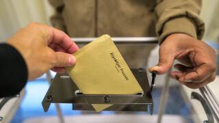 View of a person cast his ballot with the inscription Republique Francaise, French Republic, as he votes for the elections in France