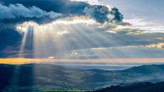 Shafts of light break through the cloud layer over Exmoor, bringing the hope of fine weather.