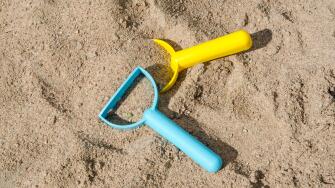 Closeup of plastic toys in a sandbox - conceptual sandbox level