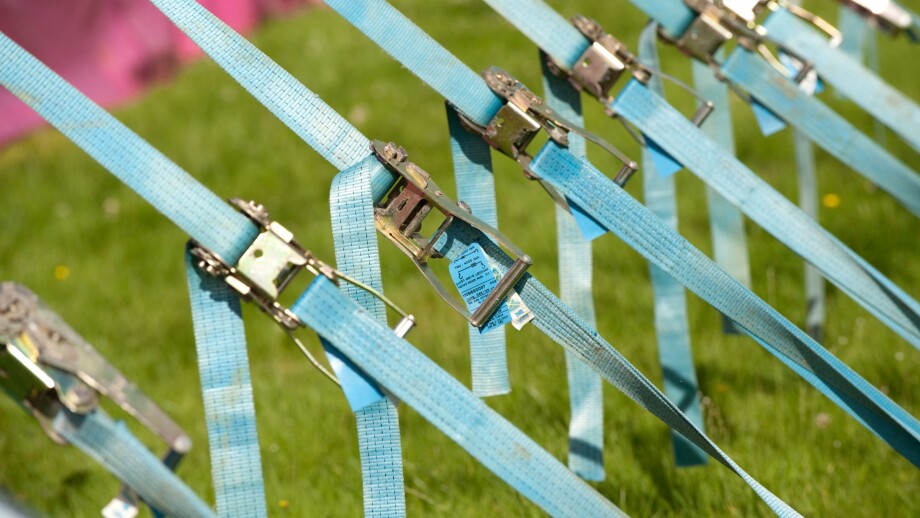 Row of tension tightening straps and pulleys on a large marquee